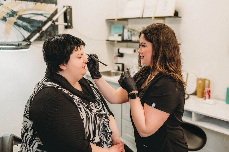 Rachel Rife, LPN, wearing gloves and working on a client in her Petoskey studio